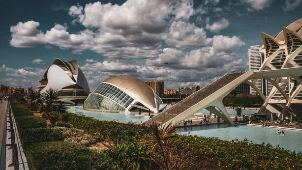 A modern architectural complex with unique structures, a central pool, and a bridge. - VidaCalma Apto 2 (Valencia)