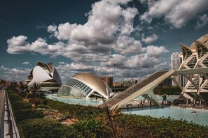 Un complesso architettonico moderno con strutture uniche, una piscina centrale e un ponte.