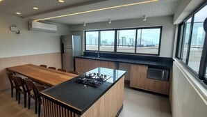 Une cuisine moderne avec un coin repas, de grandes fenêtres et une vue sur la ville.