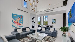 Un ampio soggiorno dal design moderno, con un grande divano componibile, un tavolino in vetro e opere d'arte alle pareti.