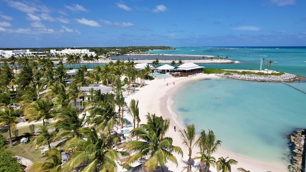 A beach resort with multiple pools, palm trees, and a sandy beach. - Las Palmas 3: Luxury retreat w/ pool, Jacuzzi, games, golf carts & full staff (Punta Cana)