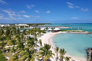 A beach resort with multiple pools, palm trees, and a sandy beach. - Las Palmas 3: Luxury retreat w/ pool, Jacuzzi, games, golf carts & full staff (Punta Cana)