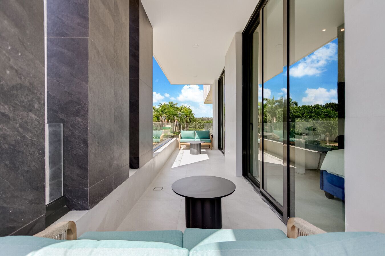 A modern interior with a balcony, large windows, and a view of the outdoors.
