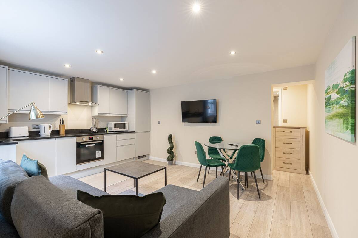 Een modern appartement met keuken, eethoek en woonkamer.