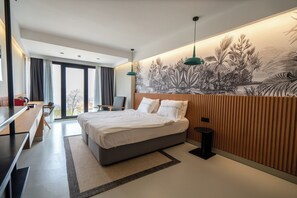 A modern hotel room with a large bed, a desk, and a view of the outdoors. - Zimmer Bosphorus Hotel (Istanbul)