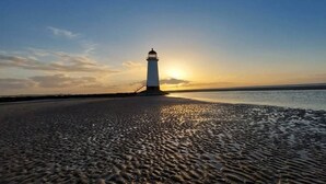 A lighthouse on a beach with a clear sky. - North Wales Coastal Stay 2 (Rhyl)