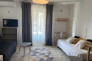 Ein modernes Wohnzimmer mit einer Couch, einem Fernseher, einem kleinen Tisch und einem Musterboden.
