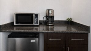 Ett kök med mikrovågsugn, kaffebryggare och diskmaskin.