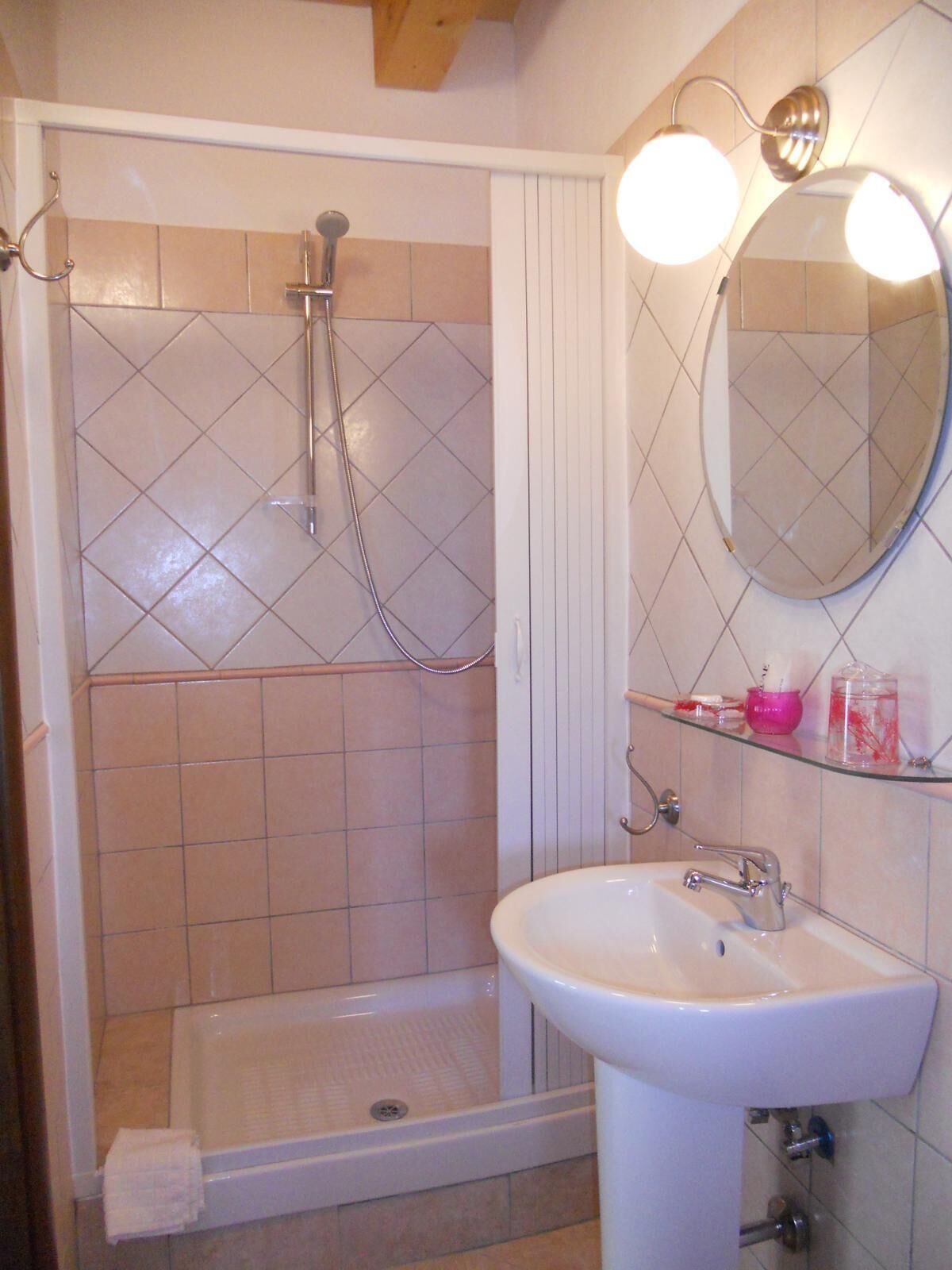 Une salle de bain avec une douche, un lavabo et un miroir.