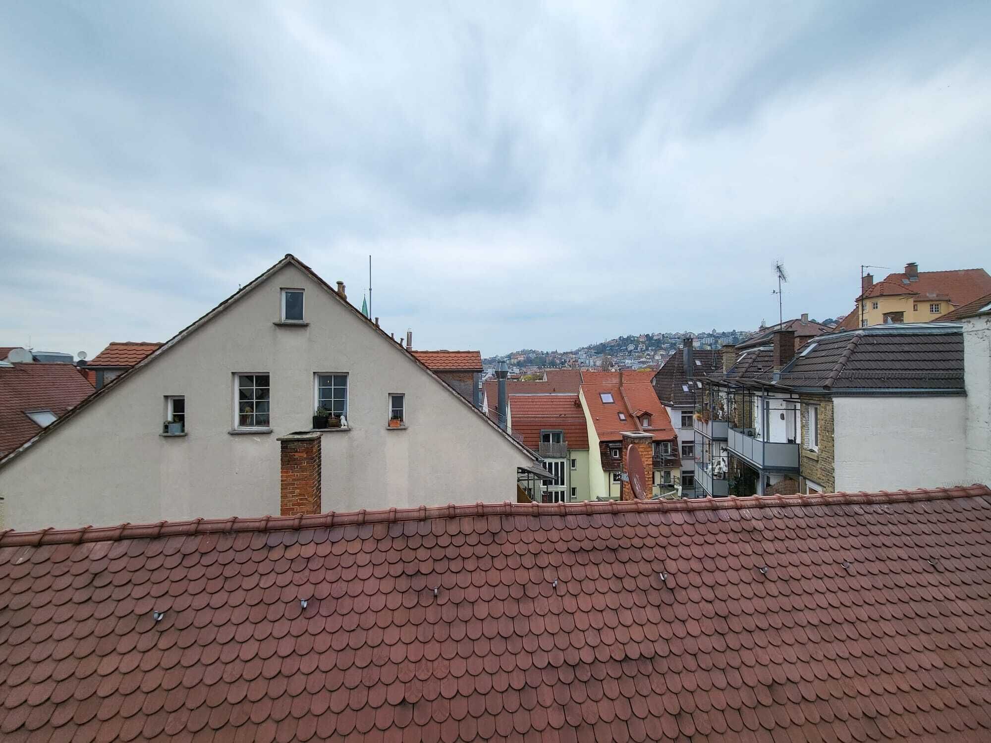 Ein Wohngebiet mit einem markanten Gebäude, das ein dreieckiges Dach und zahlreiche Fenster hat.