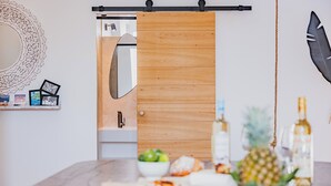 Una cocina moderna con puerta corredera de madera, encimera de mármol y diversos alimentos.