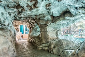 A cave-like structure with a tiled pathway leading to an exit. - 🌊Lazy River | Lagoon Pool + Splash Pad | Walk to Beach | Waterscape 205B⛱️ (Fort Walton Beach)