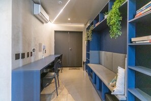 Een moderne kantoorruimte met een lange tafel, stoelen, een boekenkast en een deur.
