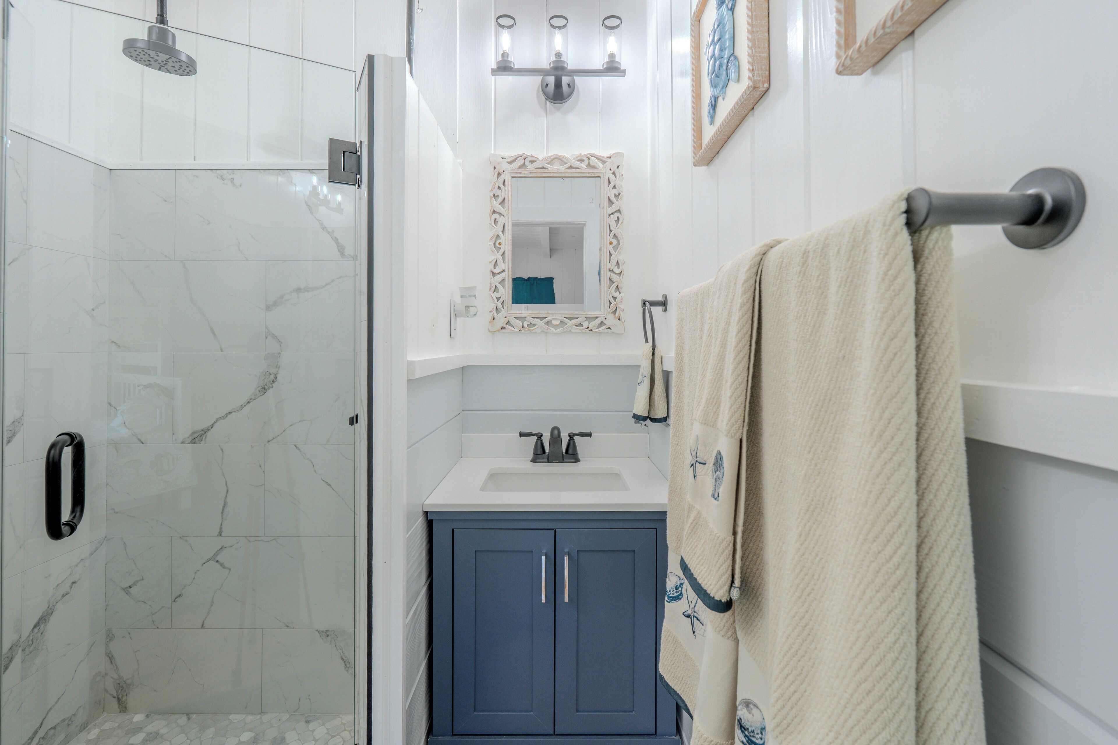 A bathroom with a shower, sink, and vanity.