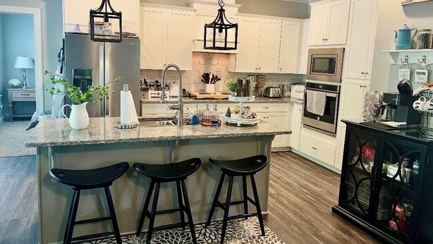 A modern kitchen with a central island, bar stools, and a coffee station. - Spacious 5-bedroom house in Evans- Perfect for the Masters Golf Tournament (Evans)