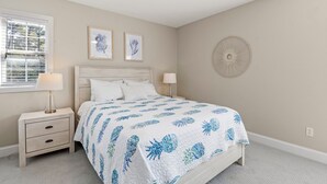 Un dormitorio con cama, mesita de noche, lámpara y decoración en la pared.