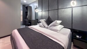 A modern hotel room with a large bed, a desk, and a wardrobe. - PEREGRINE HOTEL BY BOULEVARD (Jos)