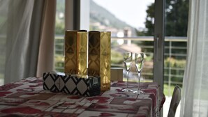 A table with a patterned tablecloth, three cylindrical containers, two wine glasses, and a decorative box. - A 5 minuti dal Lago di Tenno, spaziosa villa con piscina vista Lago di Garda (Trentino-Alto Adige)