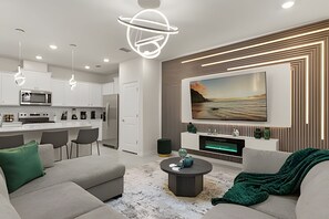 Ein modernes Wohnzimmer mit einer Couch, einem Couchtisch und einem an der Wand montierten Fernseher.