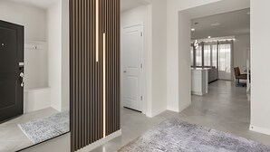 Ein modernes Interieur mit einer zentralen Säule, einer Küchenzeile und einer Sitzecke.