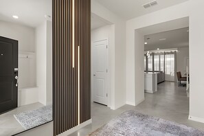 Ein modernes Interieur mit einer zentralen Säule, einer Küchenzeile und einer Sitzecke.