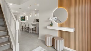 Un intérieur moderne comprenant un escalier, un coin repas et une cuisine.