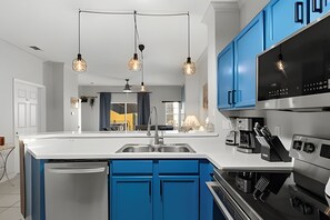 A modern kitchen with blue cabinets, a stainless steel refrigerator, a double sink, and a built-in oven. - 3 Bd / 2,5 Ba / Sleeps 08/ Terra Verde Resort (Kissimmee)