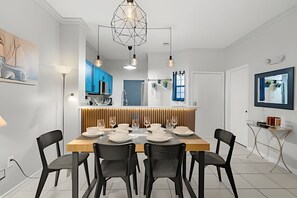 A modern dining area with a wooden table set for six, black chairs, and pendant lighting. - 3 Bd / 2,5 Ba / Sleeps 08/ Terra Verde Resort (Kissimmee)