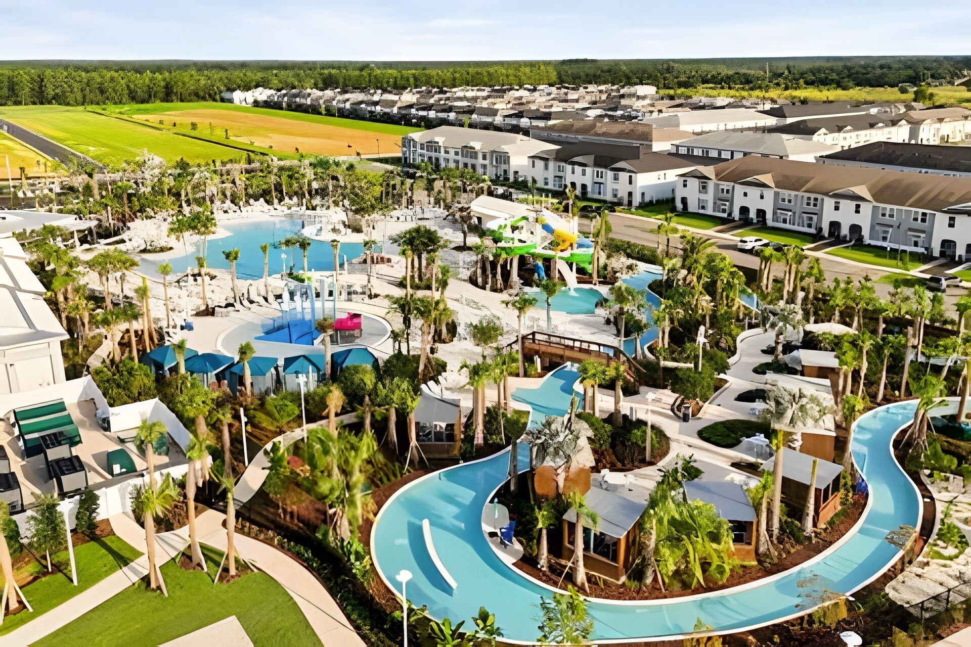 Oversigtsbillede af et resort med flere swimmingpools, palmer og en golfbane i baggrunden.