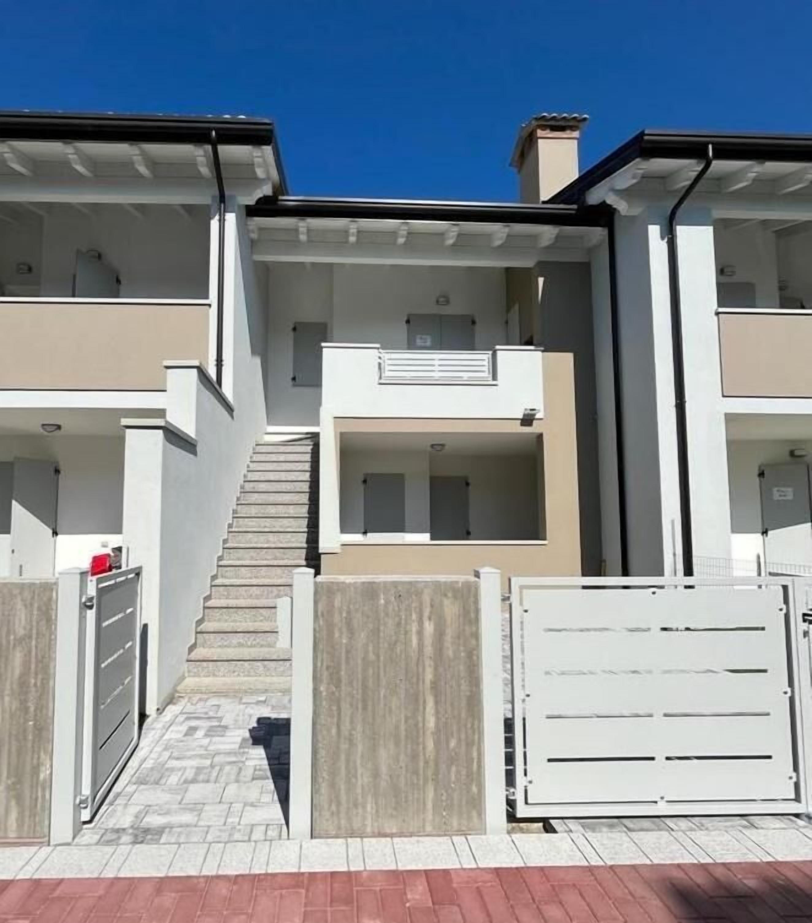 A modern apartment building with a central staircase leading to the upper floors.