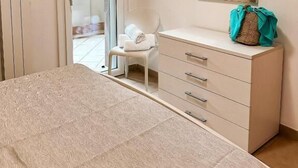 A bedroom with a bed, a dresser, a mirror, and a chair. - Pomposa Residence (Lido di Pomposa)