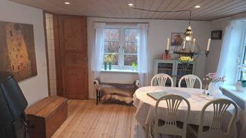 A cozy dining area with a wooden table, white chairs, and a bench.