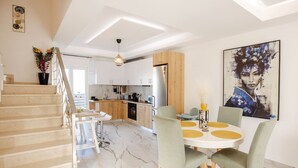 A modern kitchen with white cabinets, a wooden countertop, and a built-in oven. - Spacious Gournes Home for 7 | 2.5 Baths (Gournes)