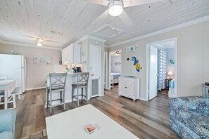 A spacious living area with a dining table, kitchen, and a sofa. - 🐾Pet Friendly | Community Pool + Walk to Beach | Sea and Sun Unit 6🐾 (Gulf Shores)