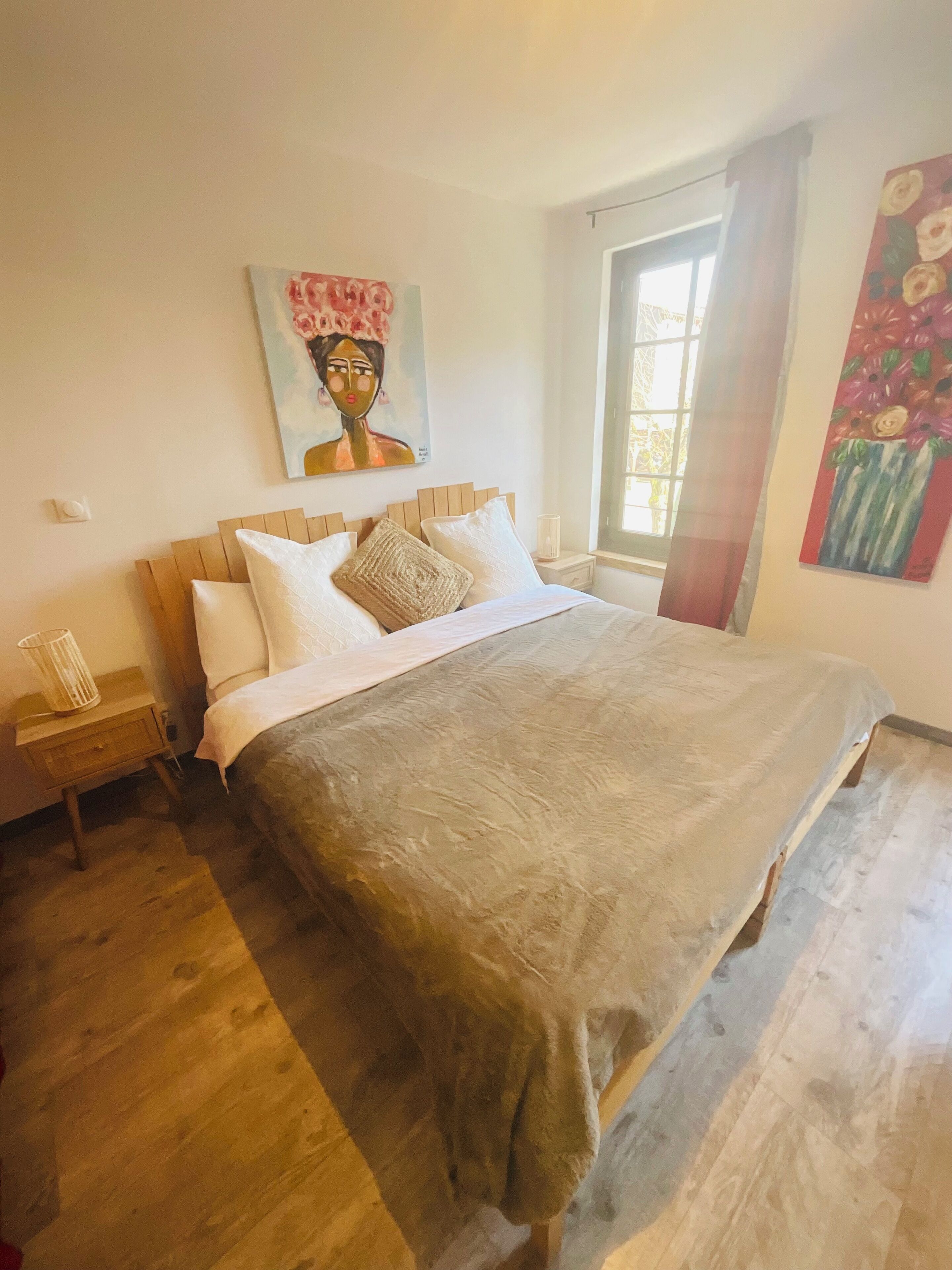 Una camera da letto con un letto grande, una testiera in legno e un quadro appeso al muro.