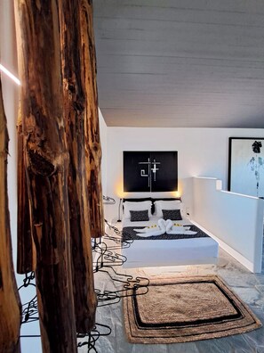 Un dormitorio moderno con una cama grande, un cabecero de madera y una obra de arte de gran tamaño sobre la cama.