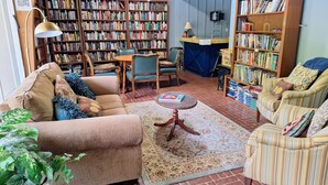 Ein gemütliches Wohnzimmer mit Kamin, Bücherregalen und bequemen Sitzgelegenheiten.