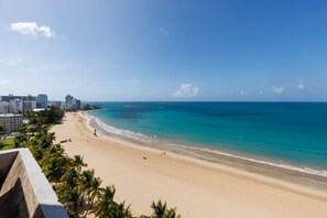 A beach with a clear view of the ocean and a cityscape in the background. - Isla Verde Oceanview 4BR With Private Beach Access (Carolina)