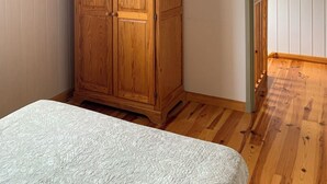 A bedroom with a wooden wardrobe, a bed, and a wooden ceiling. - Le soleil d'eau 3 villa with terrace, parking (Meyras)