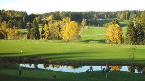 A golf course with a pond, trees, and a clear sky. - Landhotel Hoftaverne Atzmüller (Oberneukirchen)