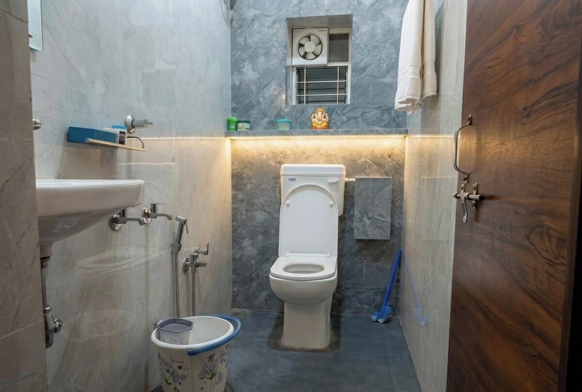 A compact bathroom with a toilet, sink, and shower.