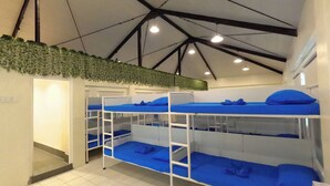 A dormitory room with bunk beds, a tiled floor, and a ceiling with exposed beams and lights. - The Luneta Seafarers Center Premier Dorm (Manila)