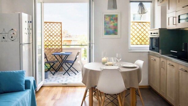 Eine moderne Küche mit Holzausstattung, einem Esstisch für zwei Personen und einem Balkon mit Blick.