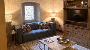 Una sala acogedora con sofá, mesa de centro y armarios de madera.