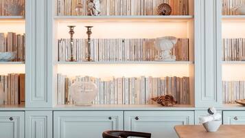 A bookshelf with books, decorative items, and a chair.
