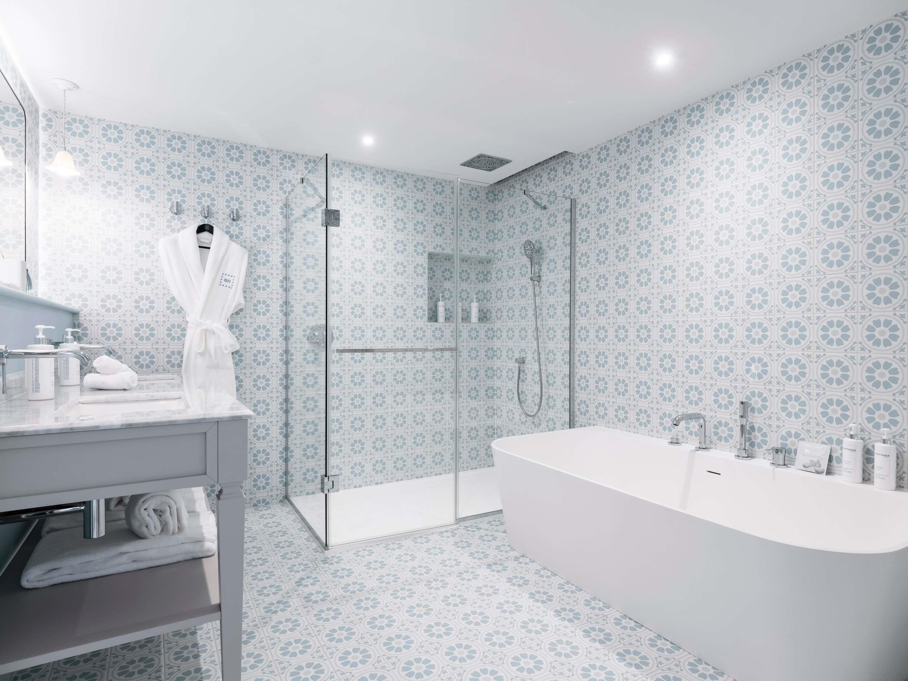 A modern bathroom with a freestanding bathtub, a glass-enclosed shower, and a vanity with a mirror and towel rack.