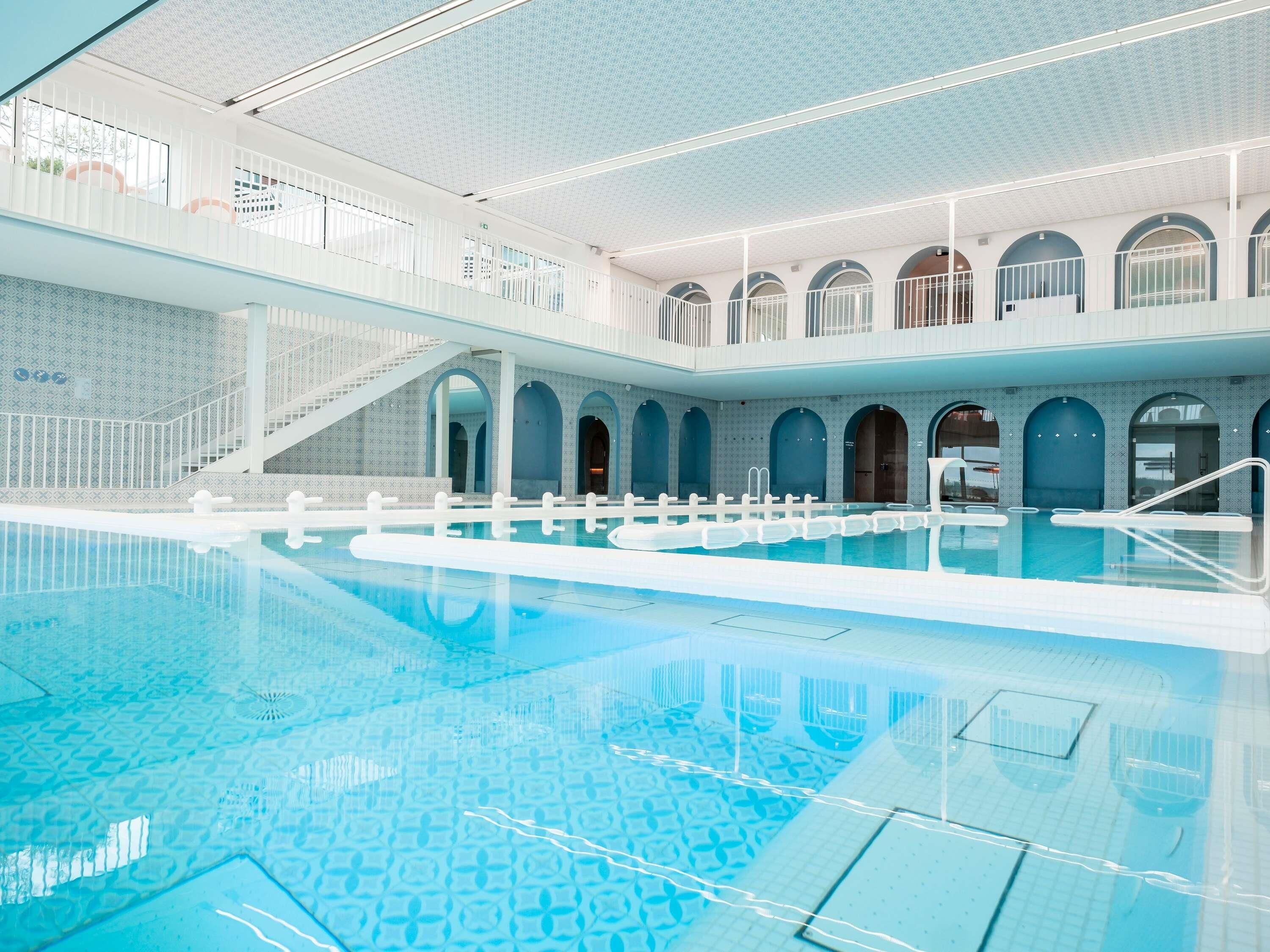 Una piscina techada, sillones reclinables de piscina
