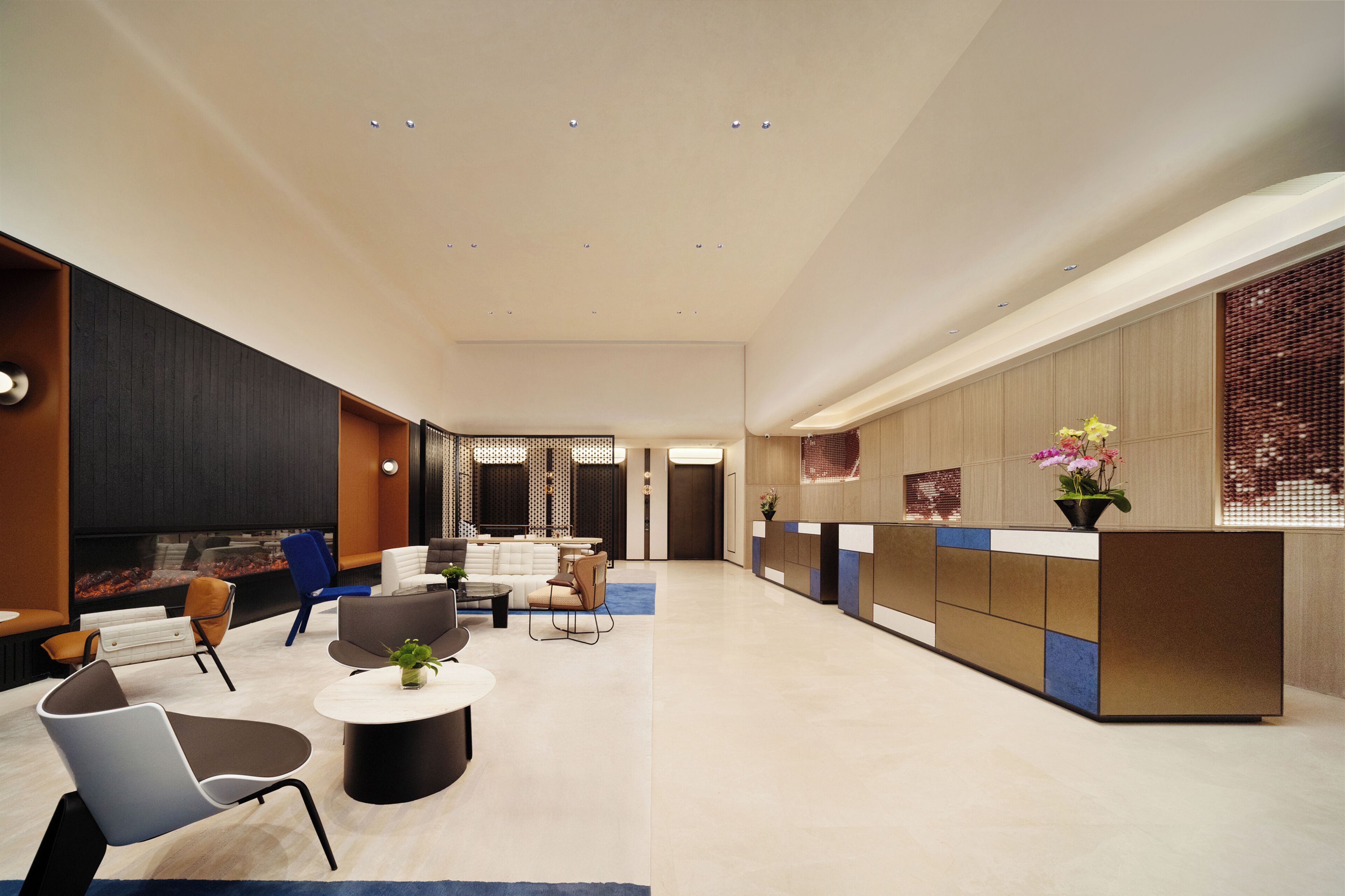 A modern hotel lobby with a reception desk, seating area, and a large window.