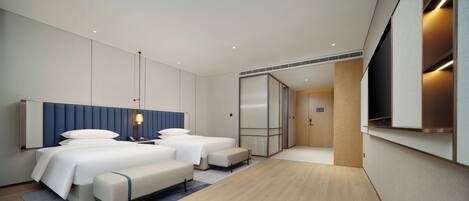 A modern hotel room with a large bed, two bedside tables, a desk, and a wardrobe.