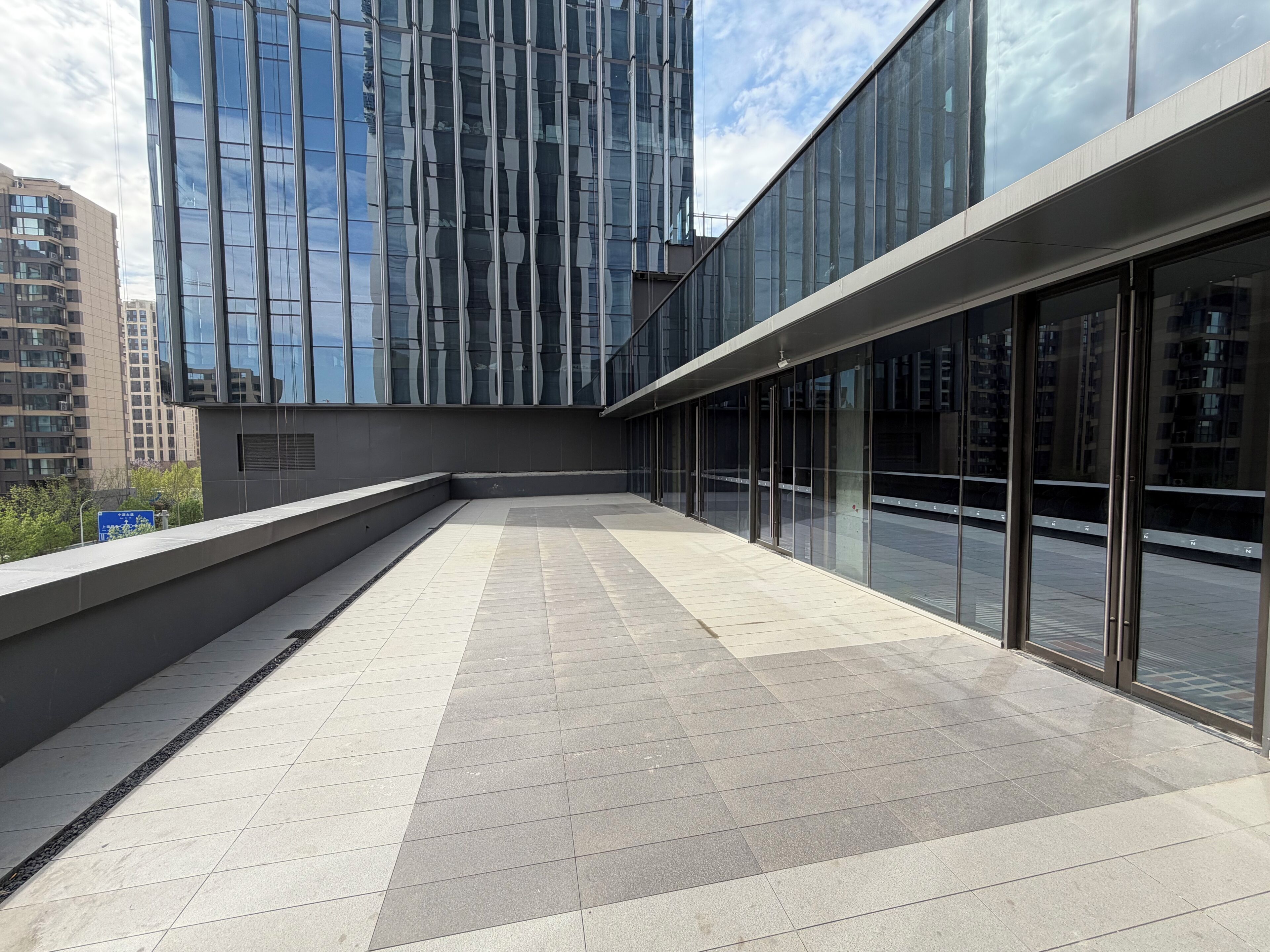 A modern building with large glass windows and a tiled floor.